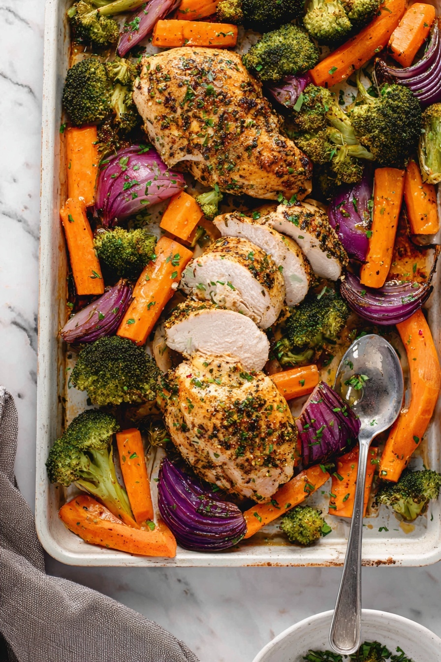 The image shows a white baking tray filled with four seasoned and cooked chicken pieces with grill marks, surrounded by bright orange carrot sticks, dark green broccoli florets, and purple-red onion wedges, all roasted with a light sprinkle of green herbs on top. One chicken piece is sliced into even strips on the lower right side of the tray, with a silver serving spoon resting nearby. The tray sits on a white marbled surface, with some green herbs scattered around and a blue cloth napkin at the bottom right corner. Photo taken with an iphone --ar 2:3 --v 7