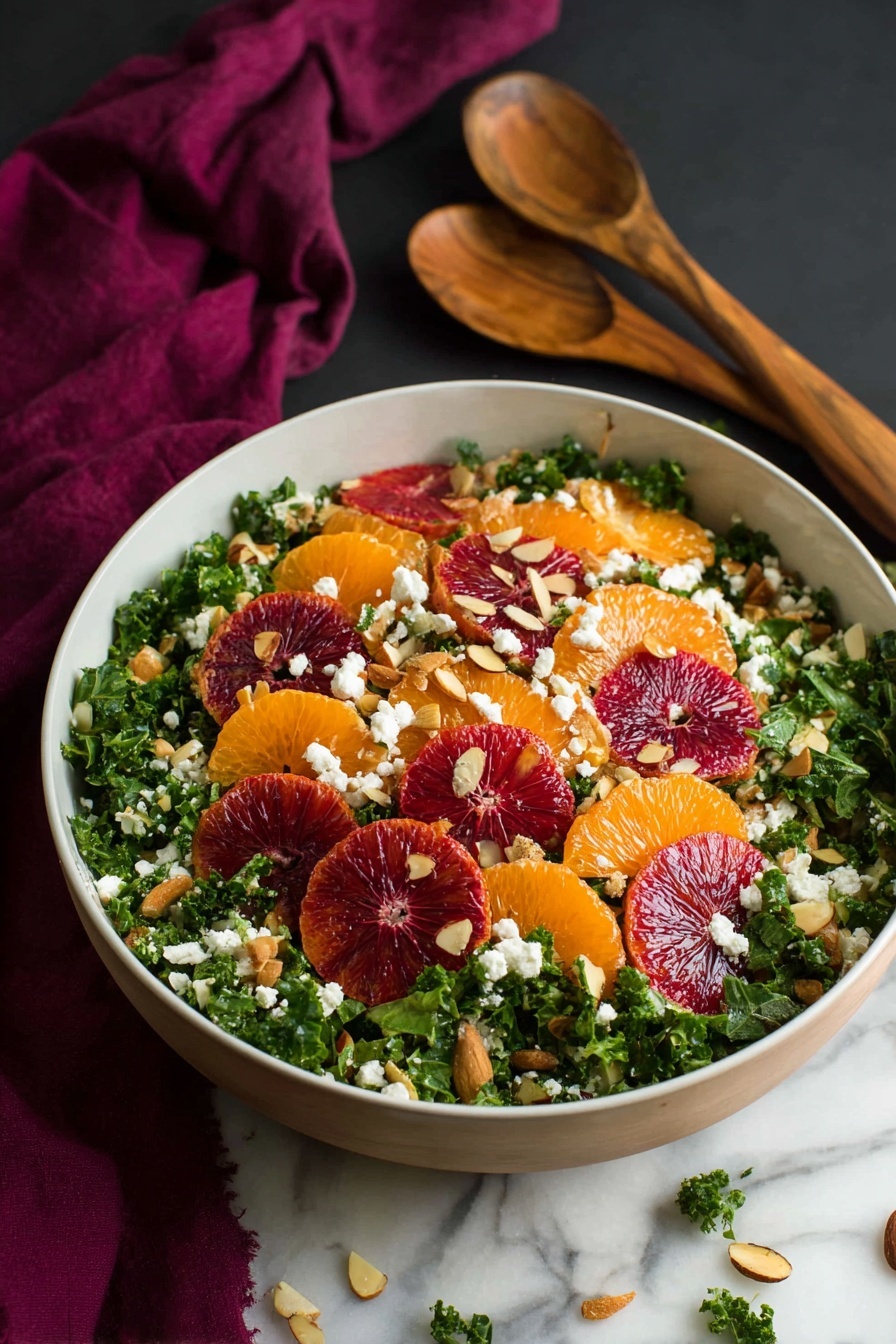 A large white dish holds a layered salad starting with a bed of dark green curly kale leaves that fill the plate. On top, there are bright orange mandarin slices and deep red blood orange wedges spread evenly. Scattered over the salad are small chunks of white cheese, light brown toasted almond slices, and some small green pieces that look like chopped green onions. Around the dish, a few almond slices and kale pieces are scattered on a white marbled surface, with a dark purple cloth partially visible under the plate. Photo taken with an iphone --ar 2:3 --v 7