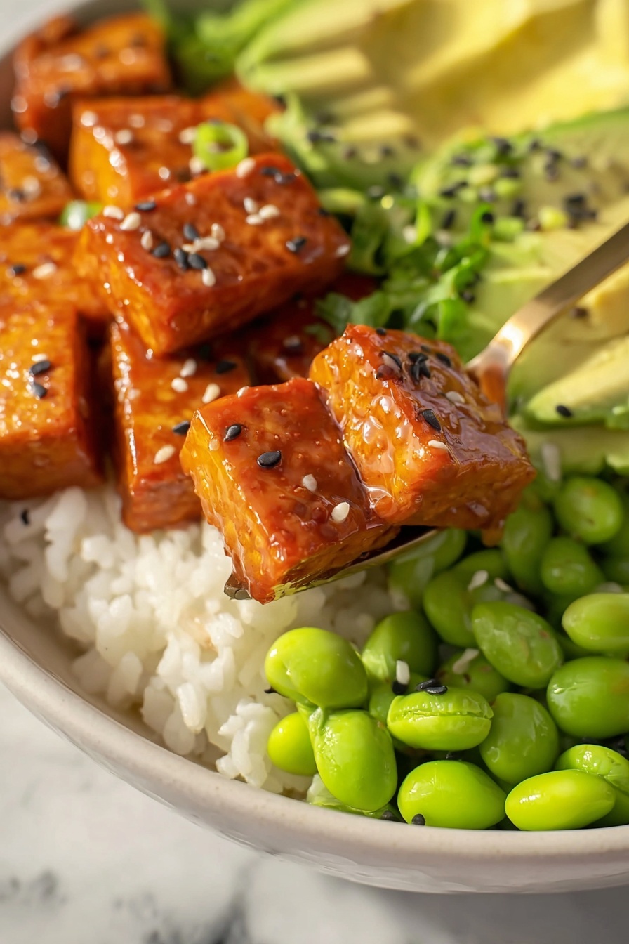This image shows a white bowl filled with four main layers. The bottom layer is off-white rice, which covers the entire base. On the right side, there are bright green edamame beans that look smooth and fresh. On the left side, slices of light green avocado fan out in neat rows sprinkled with black sesame seeds. The top center is filled with shiny, orange glazed tofu cubes topped with white and black sesame seeds and small pieces of green onion. A golden spoon is lifting two tofu cubes towards the camera. The bowl is placed on a white marbled surface. Photo taken with an iphone --ar 2:3 --v 7