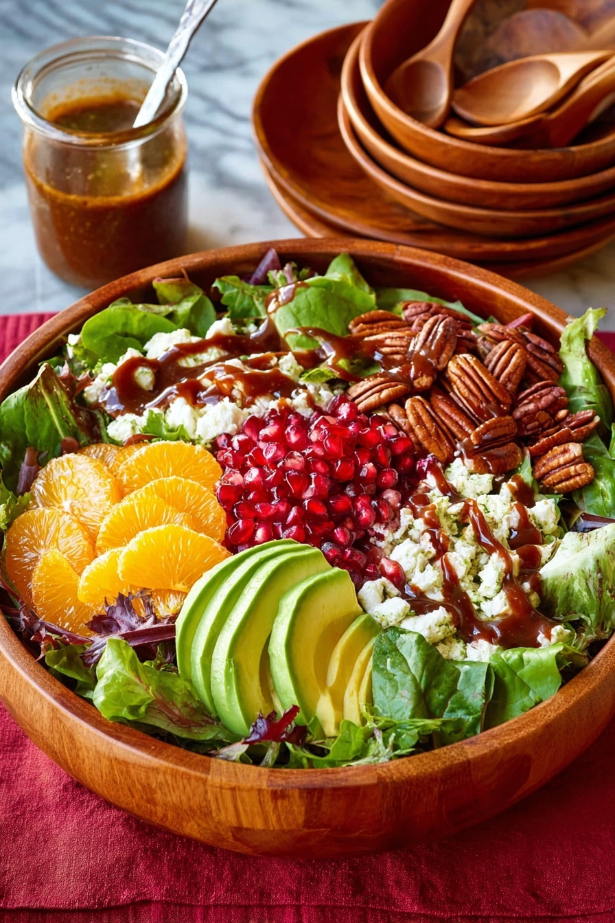 A wooden bowl sits filled with a salad layered on a base of mixed green leaves. On top, there are sections of bright red pomegranate seeds, toasted brown pecans, sliced light green avocado with brown dressing drizzled over, crumbled white cheese, and pale orange citrus slices. The bowl is on a white marbled surface with a red cloth underneath. Behind the bowl are stacked wooden bowls with silver utensils and a small glass jar of brown dressing with a spoon inside. Photo taken with an iphone --ar 2:3 --v 7