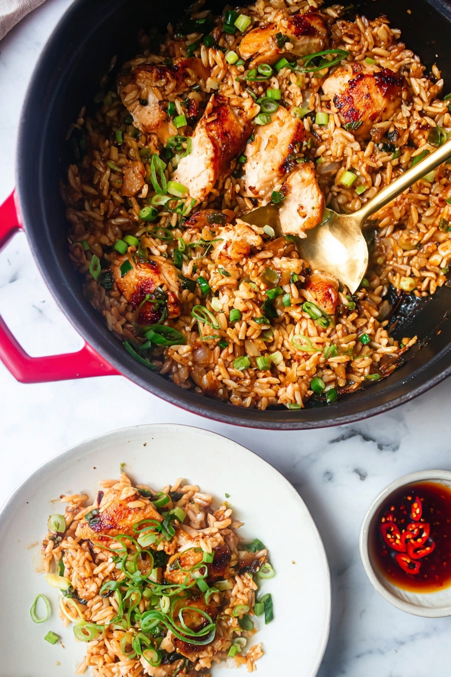 A black pot with red handles filled with a mix of small golden-brown rice-shaped pasta and browned pieces of cooked chicken, scattered with green herbs and black sesame seeds. A gold spoon is inside the pot, scooping some of the pasta and chicken. Below the pot, a white plate holds a serving of the pasta and chicken topped with bright green sliced spring onions. To the right, a white bowl contains some reddish-brown sauce with visible spices. The whole scene is set on a white marbled surface. photo taken with an iphone --ar 2:3 --v 7