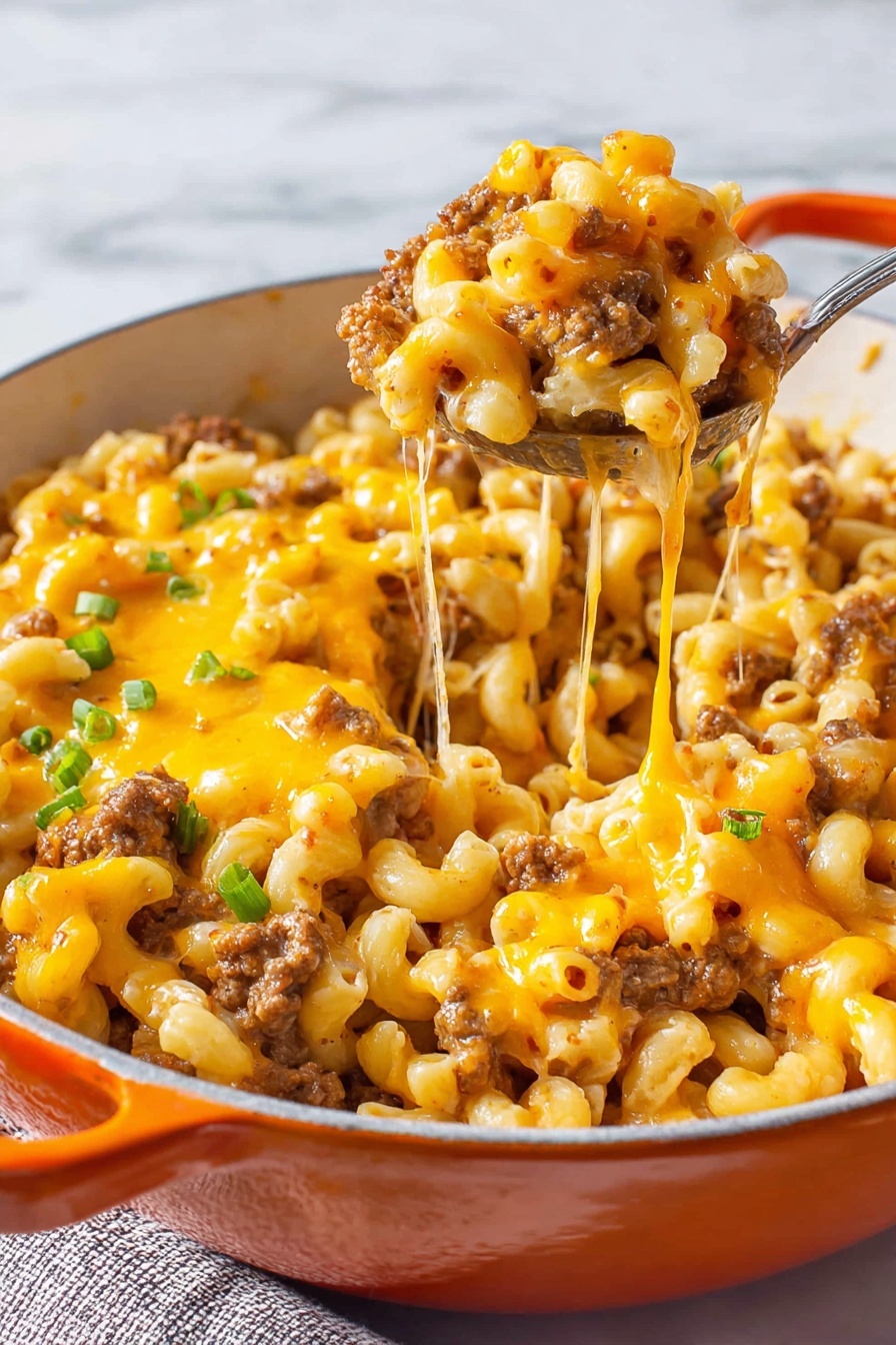 The dish is a warm, cheesy macaroni bake served in a white pot with orange handles. It has multiple layers with a base of small elbow macaroni pasta mixed with browned ground meat and diced tomatoes. On top, there is a thick layer of melted bright orange cheddar cheese that stretches as a spoon lifts a portion. Small green slices of spring onion are sprinkled over the cheese, adding a pop of color. The texture shows a mix of creamy melted cheese, tender pasta, and browned meat bits. The background surface is a white marbled texture. photo taken with an iphone --ar 2:3 --v 7