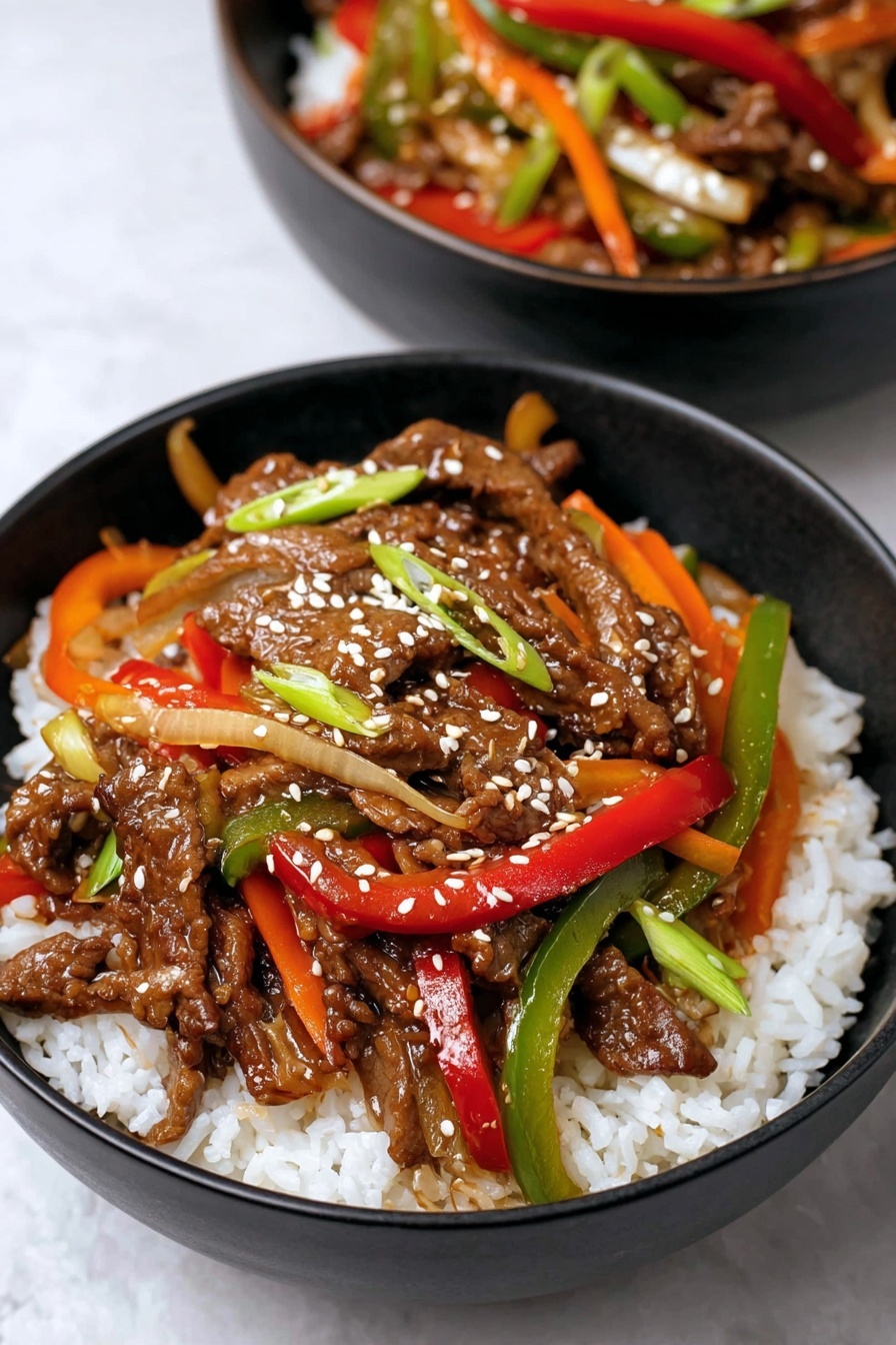 A black bowl filled with a base layer of white, fluffy rice. On top, there is a colorful mix of stir-fried beef strips coated in a shiny brown sauce, scattered with sesame seeds. Among the beef, there are thin strips of red, green, and orange bell peppers, along with some green onions and translucent cooked onions, adding bright colors and varied textures. The bowl is placed on a white marbled surface, with part of a second bowl of the same dish blurred in the background. photo taken with an iphone --ar 2:3 --v 7